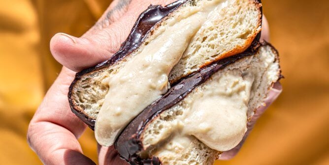 hand holding a vegan Boston Dream donut from Level 5 Donuts