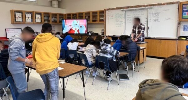 A classroom where a teacher is demoing how to dissect a synfrog with their students