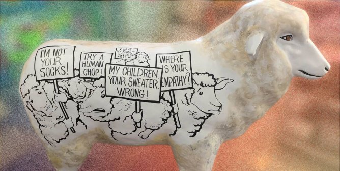 PETA's sheep statue with drawn protesting sheep on the side on the statue.