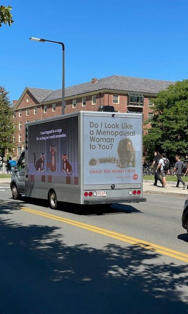 Truck with billboards on it. The text on the back reads "Do I Look like a menopausal woman to you?" with a photo of a marmoset
