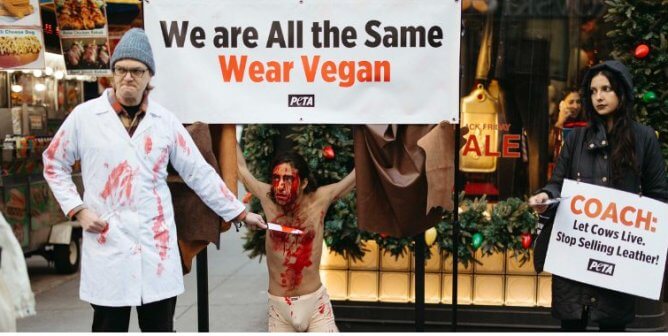 Demonstrators in costumes protesting in front of a Coach store