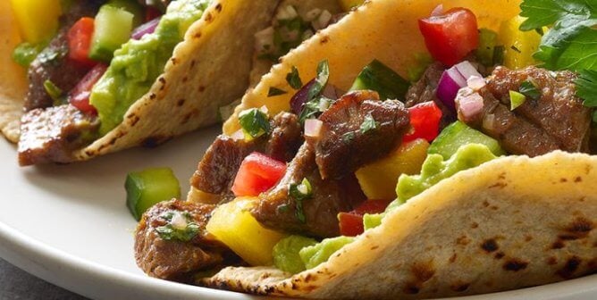 Two soft tacos filled with beyond meat steak and vegetables