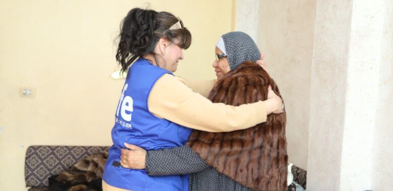 A volunteer embracing a refugee from Jordan