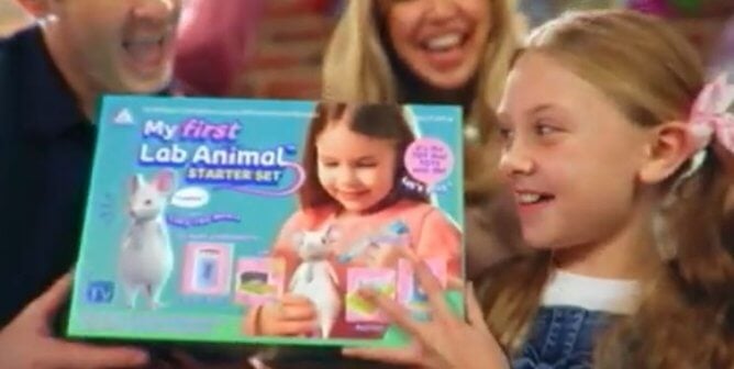 A girl holding up a My First Lab Animal toy