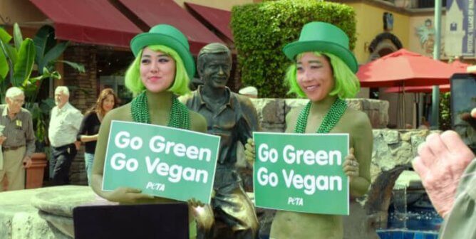 Two demonstrators in green costumes