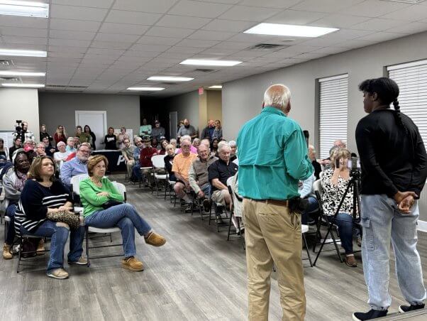 People packed in a conference room for a town hall meeting