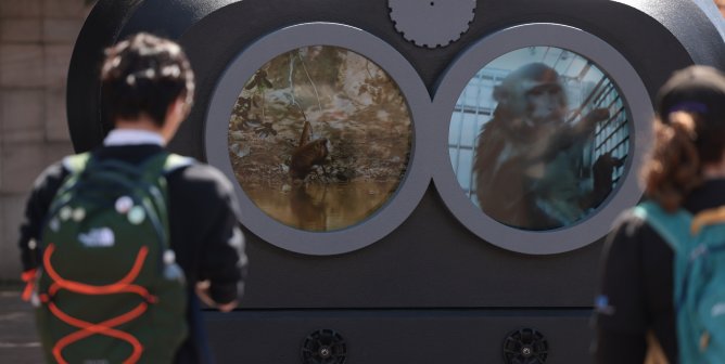 Two students looking at the two video feeds in the binocular lenses of our display