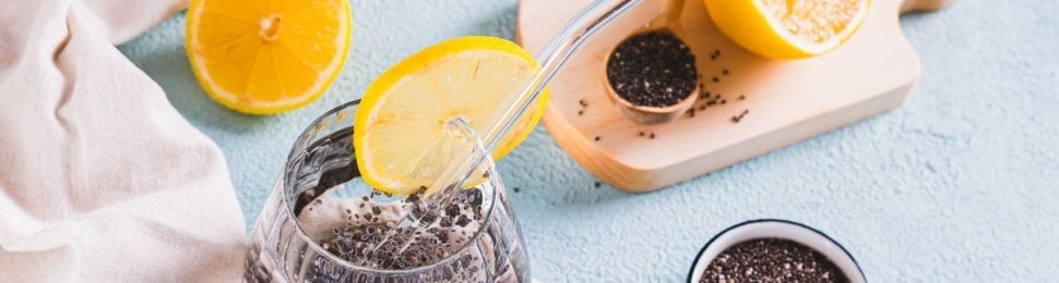 Chia seed water next to bowl of seeds and sliced citrus fruit