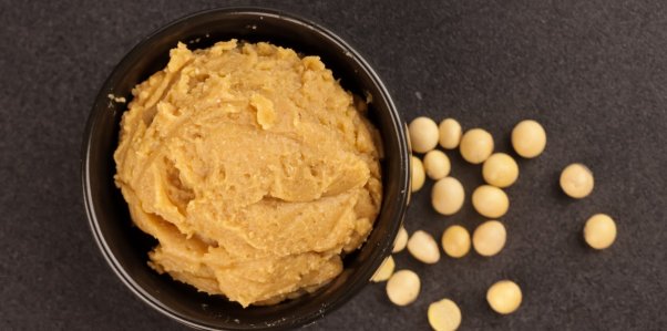 Miso paste in a bowl with scattered chickpeas