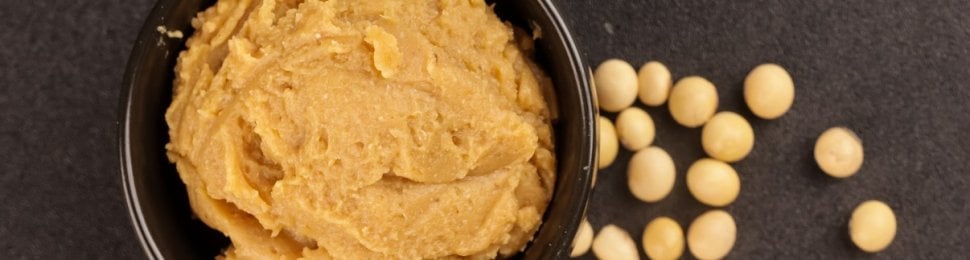 Miso paste in a bowl with scattered chickpeas