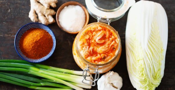 A jar of kimchi alongside the ingredients to make it