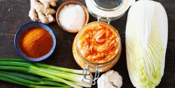A jar of kimchi alongside the ingredients to make it