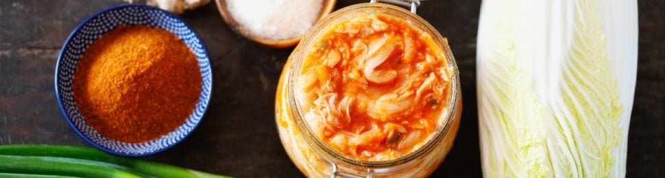 A jar of kimchi alongside the ingredients to make it