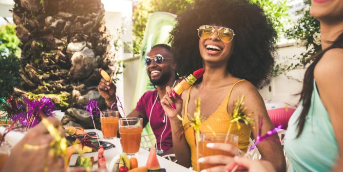 Happy friends having fruit and drinks