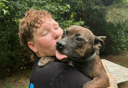Rescuer holding a brown dog