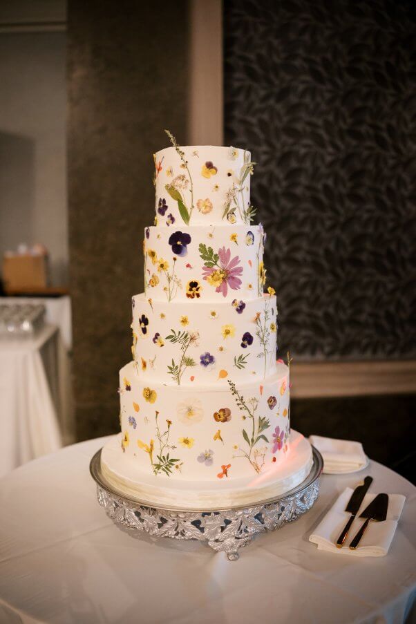A white wedding cake covered in edible flowers