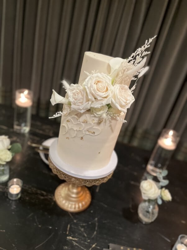A white wedding cake with white roses