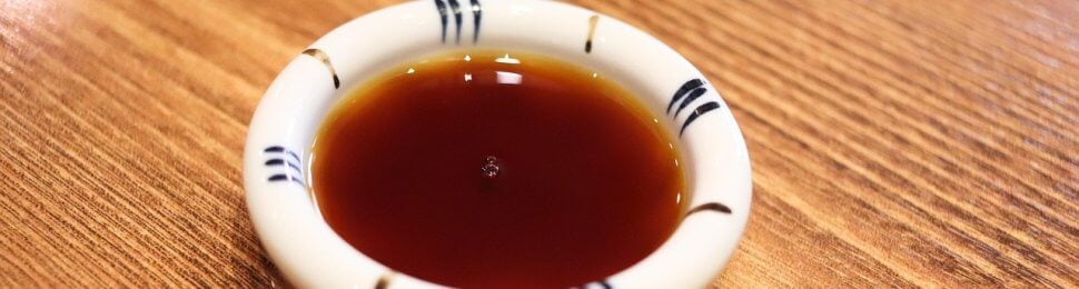 a small bowl of Worcestershire sauce on a wooden table