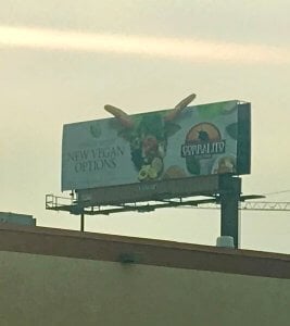 billboard advertising vegan options at a steakhouse