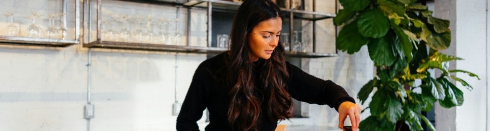 A woman cooking with an orange pots and pans set