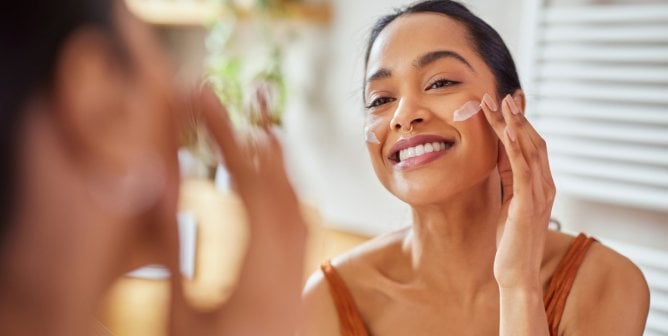 Woman applying moisturizer