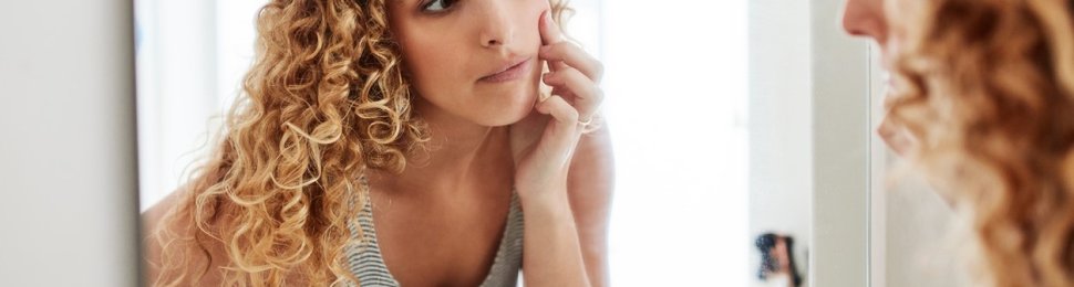 Blonde woman looking in mirror
