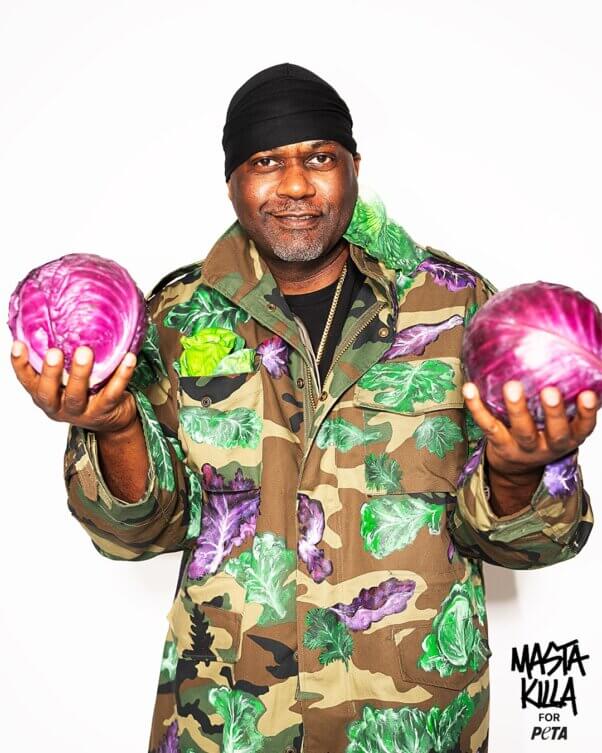 Masta Killa posing with two purple cabbages