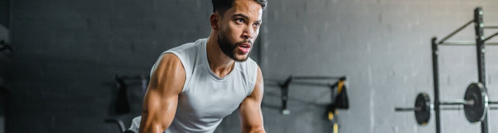 Muscular man working out with battle ropes