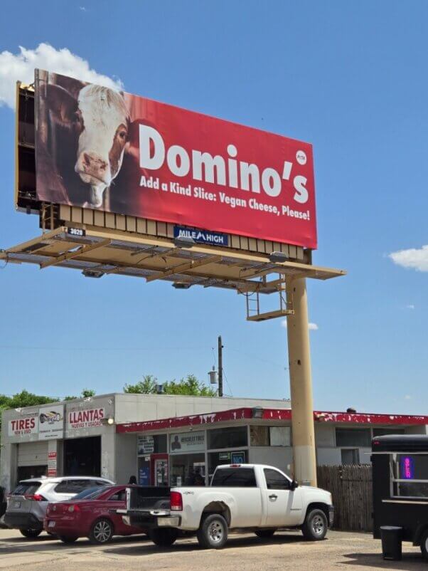 a billboard urging domino's to add vegan cheese