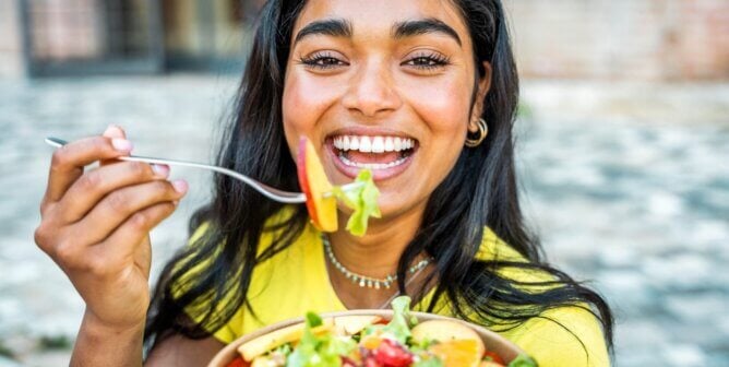 Woman eating colorful salad