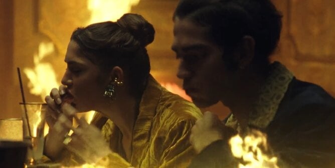 A still from PETA's Room on Fire ad shows two people eating meat in a dining room that is on fire.