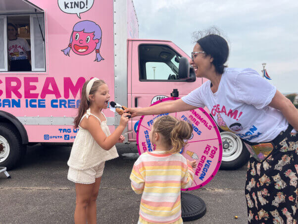 A volunteer giving vegan ice cream to children