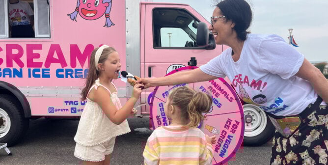 A volunteer giving vegan ice cream to children