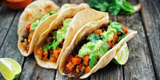 Vegan tacos in corn tortillas with wedges of lime. yum.