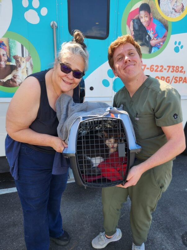 Volunteer with client and cat carrier