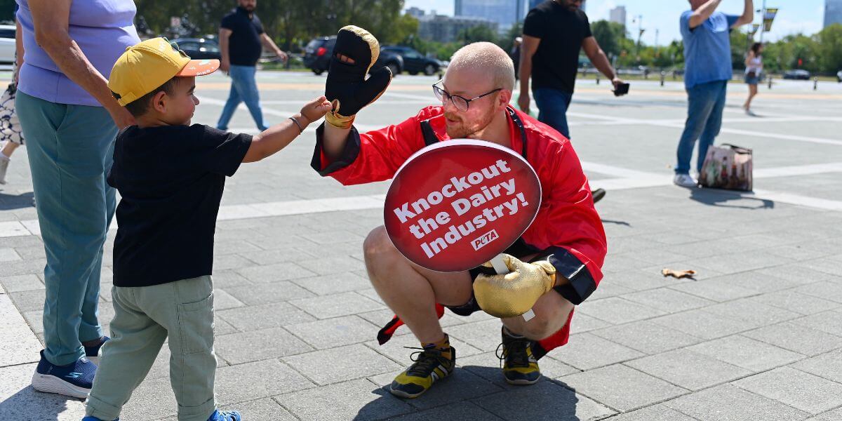 A man dressed as a boxer high-fiving a child