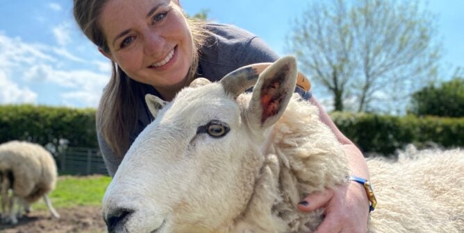 happy woman hugging a sheep