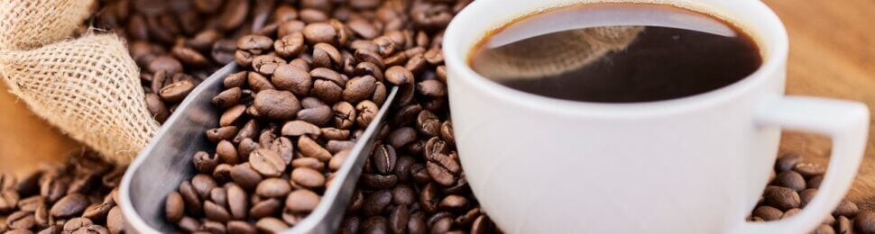 a cup of black coffee and a bag of coffee beans