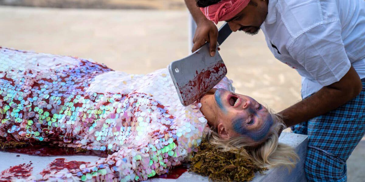 Ingrid getting mock-chopped by someone dressed as a dying fish