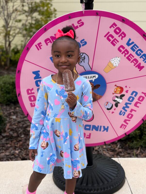 girl standing in front of peta iscream wheel to spin