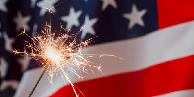 Photo of American flag and a lit sparkler