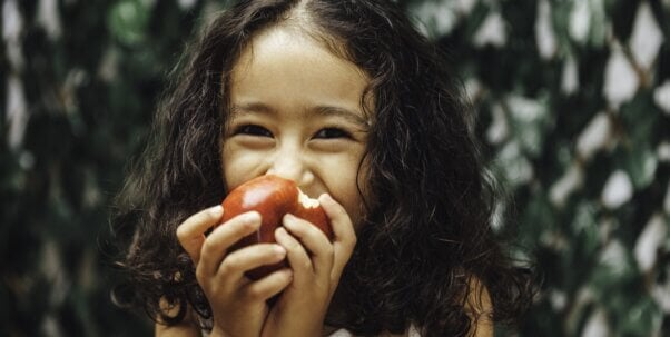 Young girl eating apple