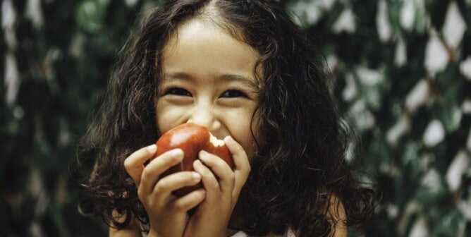 Young girl eating apple