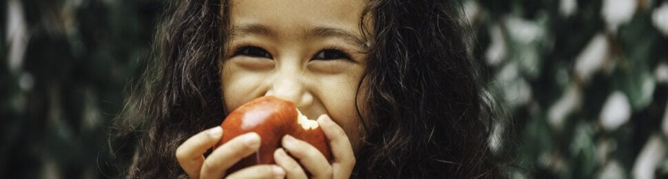 Young girl eating apple