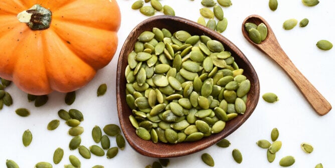 pumpkin seeds next to a pumpkin