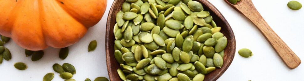 pumpkin seeds next to a pumpkin