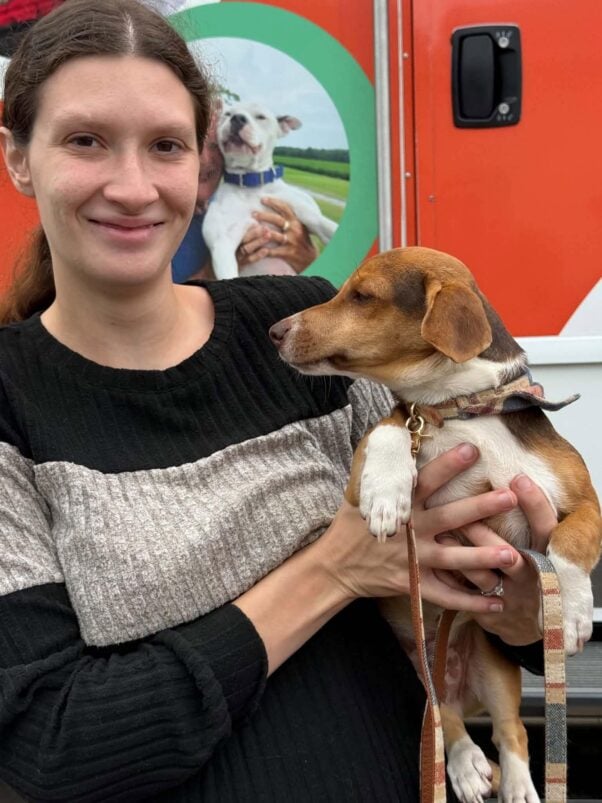 A woman and a beagle outside the mobile clinic