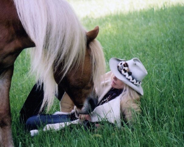 Kim Novak in a field with a horse