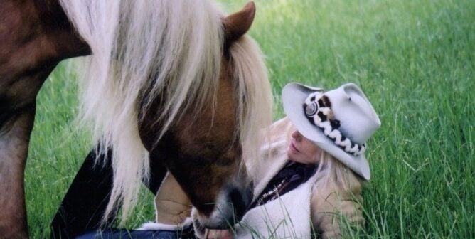 Kim Novak in a field with a horse